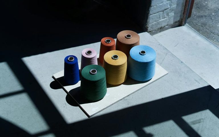 A group of seven different yarns of different colors photographed under heavy sunlight